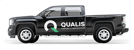 A black truck with the word quails on it, belonging to a roofing company.