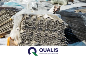 Stack of asbestos roofing sheets among auto draft construction waste at a disposal site, with a "qualis roofing & construction" logo visible.